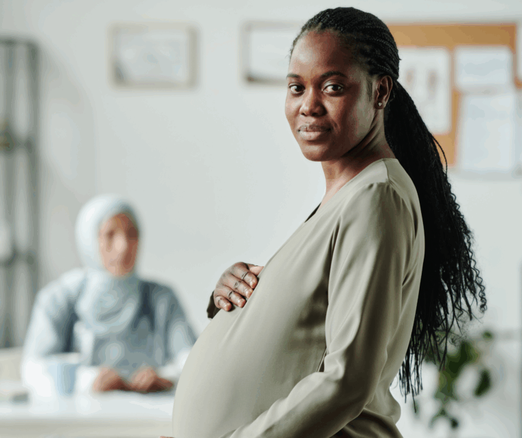 Image of a pregnant women with a doctor in the backgroung